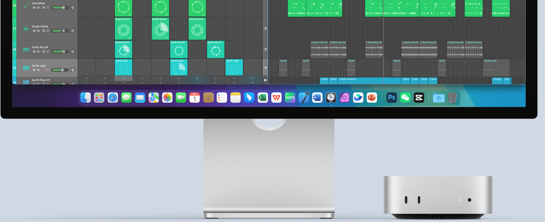 银色 Mac mini 的正面,展示正面的各个端口以及指示灯,Mac mini 摆放在 Mac 显示器右下方,显示器屏幕显示色彩缤纷的画面以及程序坞中的各个 app 图标。