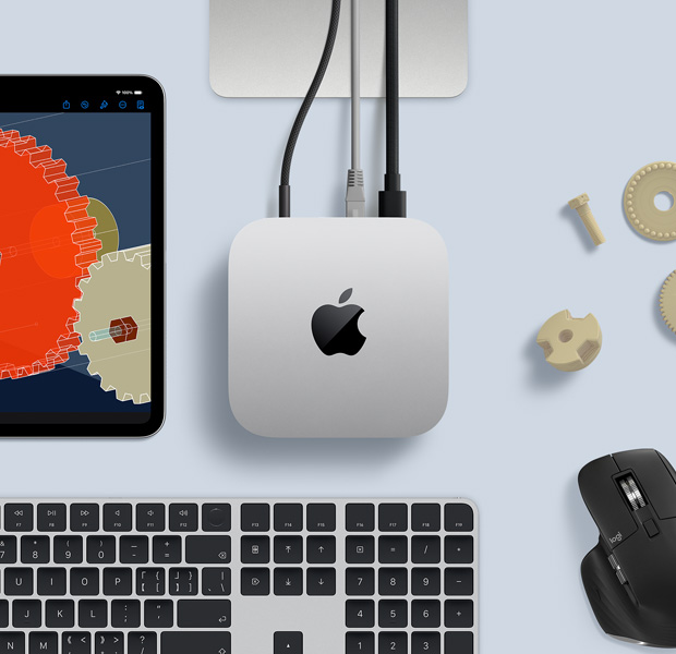 桌上的银色 Mac mini 的俯视图,设备旁边摆放着黑银配色无线键盘、黑色无线鼠标和一部 iPad。